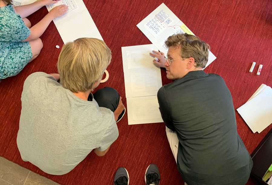 Två personer pratar om skisser under en design sprint.