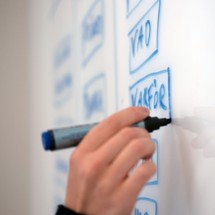 Någon skriver ordet varför på en whiteboard